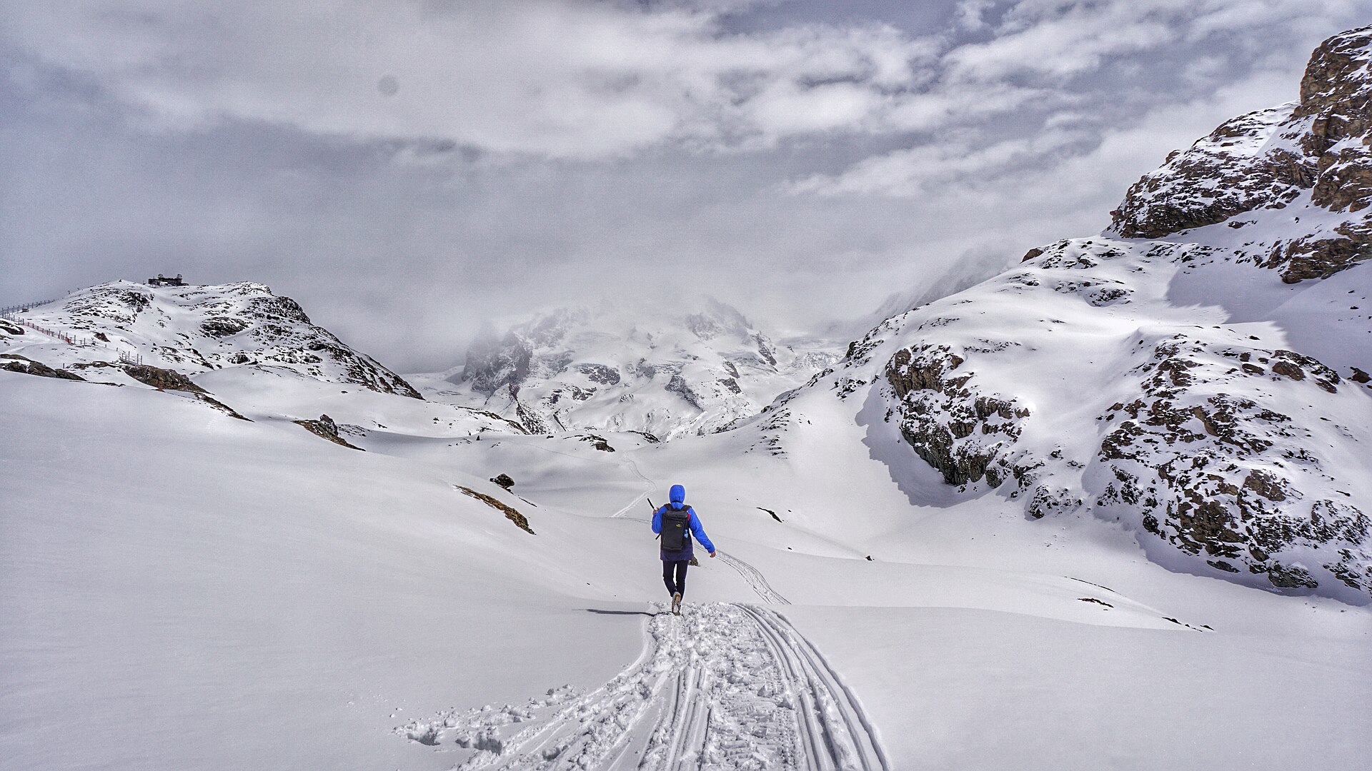 un randonneur avec son sac en montagne pour illustrer l'article Première nuit en refuge : comment se préparer sans trop charger son sac.